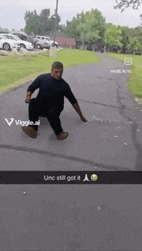a man is kneeling down on a sidewalk with the words unc still got it