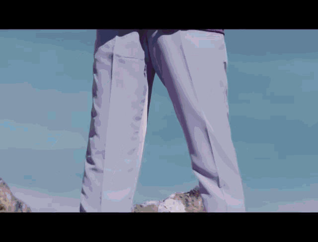 a person wearing purple pants is standing on a mountain