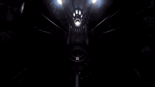 a yellow car is driving through a tunnel in a dark room .