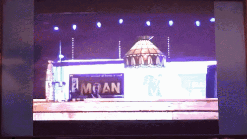 a screen shows a stage with a sign that says moan on it