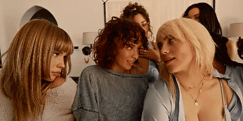 a group of women are sitting around a blonde woman