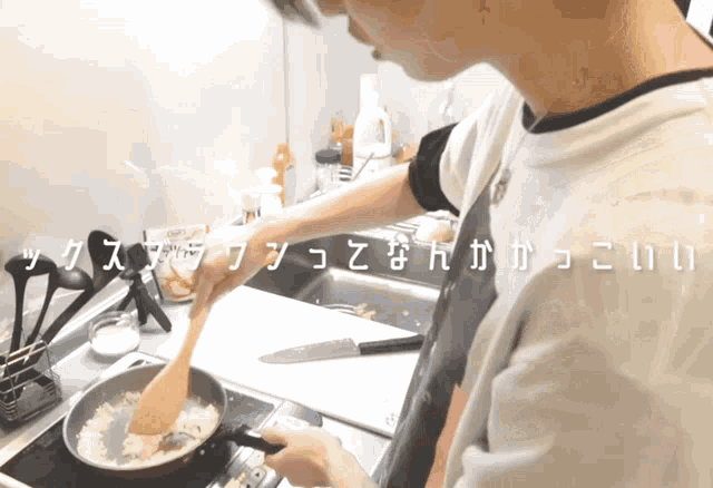 a person stirring rice in a frying pan with chinese writing on the bottom of the image