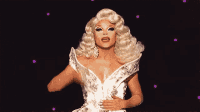 a drag queen with blonde hair and a white dress on