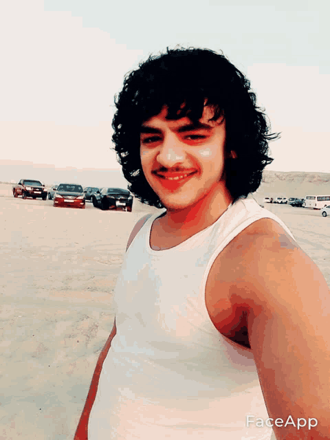 a man with curly hair and a mustache is wearing a white tank top with faceapp written on it