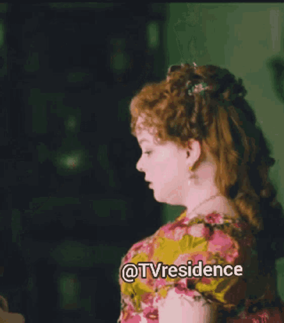 a woman in a pink and yellow dress with a flower in her hair has the words @tvresidence below her