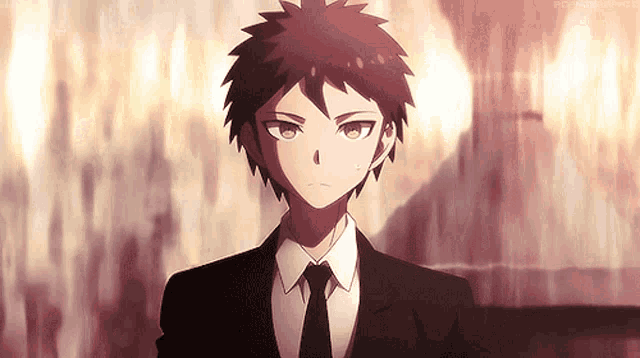 a young boy in a suit and tie is standing in front of a wall .