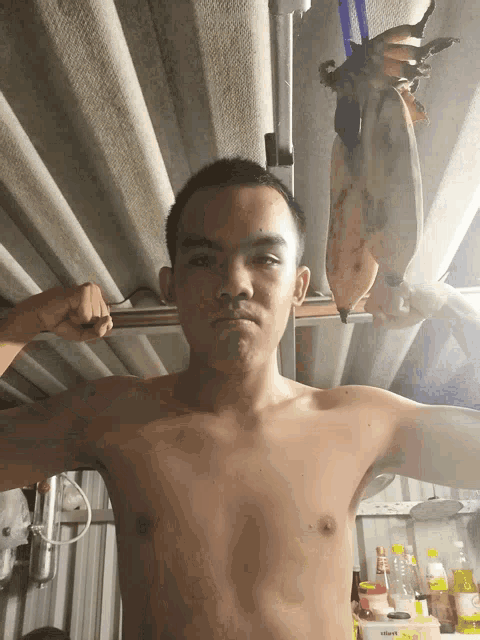 a shirtless man holds a bunch of bananas in his hands