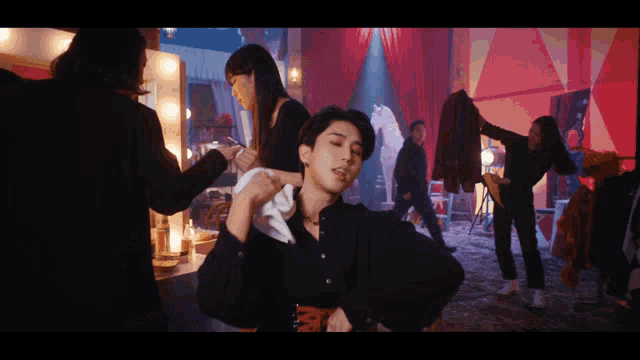a man in a black shirt is getting his hair done