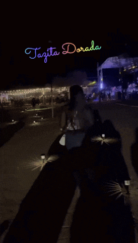 a woman is walking in front of a stage that says tazita dorada on it
