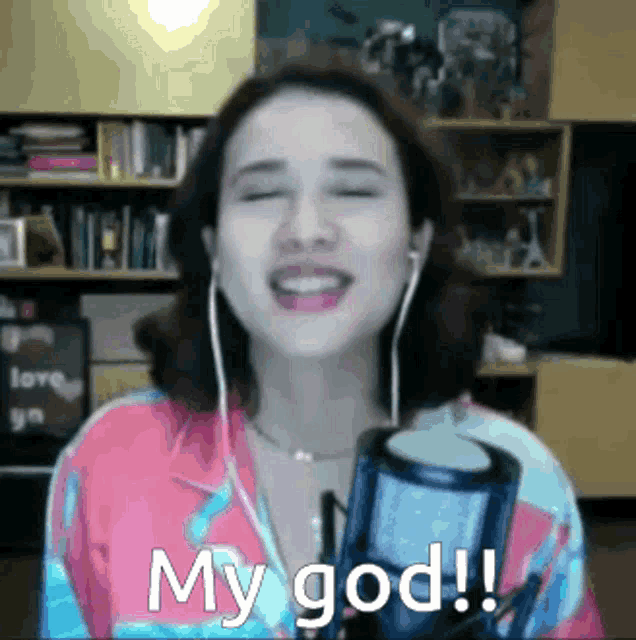 a woman singing into a microphone with her eyes closed and the words my god written below her
