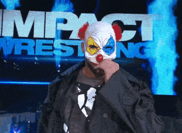 a man in a clown mask stands in front of an impact wrestling sign