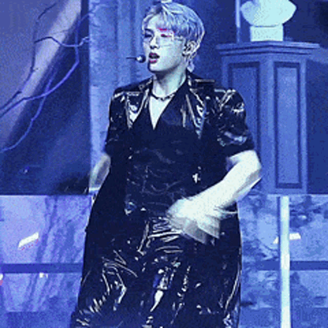 a man with a microphone in his mouth is dancing on a stage