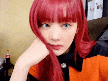 a girl with red hair and blue eyes is taking a selfie .