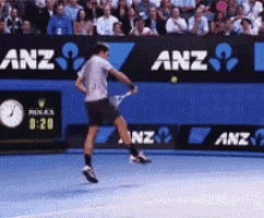 a tennis player is swinging a racket at a tennis ball in front of an anz banner