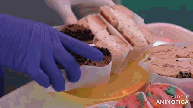 a person wearing blue gloves is reaching for a piece of cake on a table made in animatica