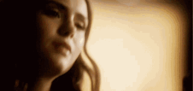 a close up of a woman 's face with a blurry background .
