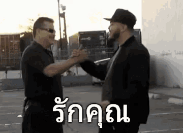 two men are shaking hands in a parking lot in a foreign language .