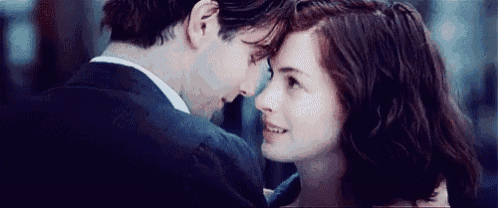 a man and a woman are looking at each other and smiling .