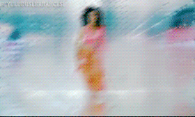 a woman in a pink top and orange pants is dancing in front of a screen that says buyutuldus.sabah.esp