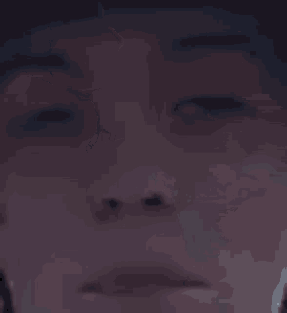 a close up of a person 's face looking out a window .