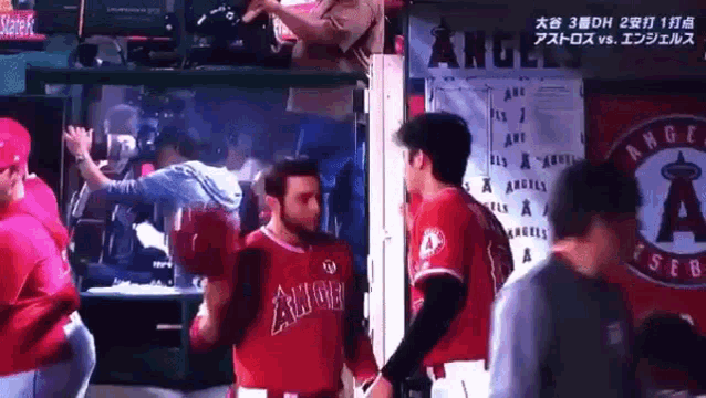 a group of angels baseball players standing in front of a sign that says angels