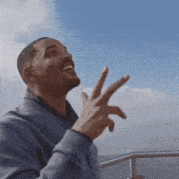 a man is making a peace sign with his fingers while laughing