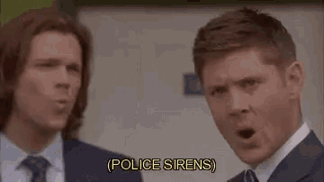 two men in suits and ties are standing next to each other and making funny faces while talking about police sirens .