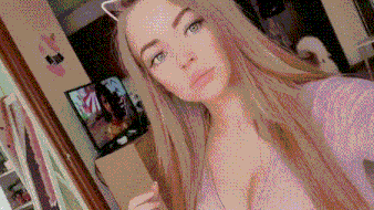 a woman is taking a selfie in front of a mirror with a cat ear headband on her head .