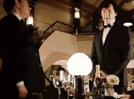 two men in tuxedos are standing next to each other