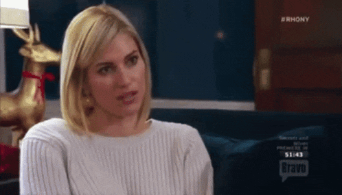 a woman sitting on a couch with bravo on the screen