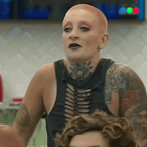 a woman with a shaved head and a lot of tattoos