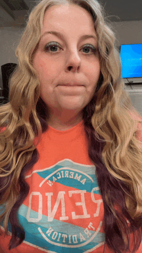 a woman is wearing an orange shirt that says oi13