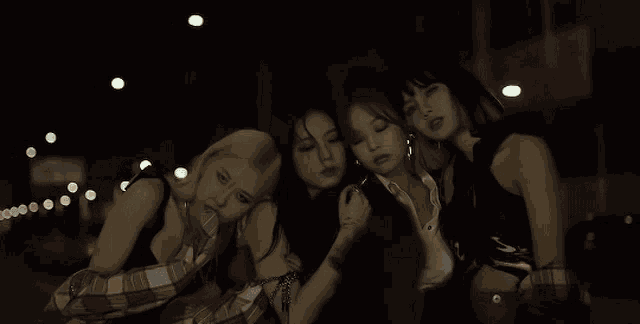 a group of women are posing for a picture together at night