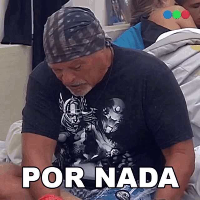 a man wearing a bandana and a black shirt says por nada