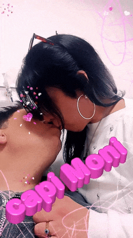 a woman is kissing a man on the forehead with the word caption written in pink