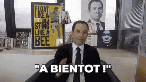 a man in a suit and tie is sitting in front of a sign that says float like a butterfly sting like a bee