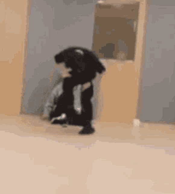 a blurry picture of a man carrying another man in a room .