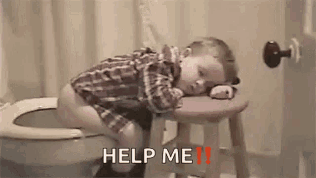 a little boy is sitting on a stool next to a toilet .