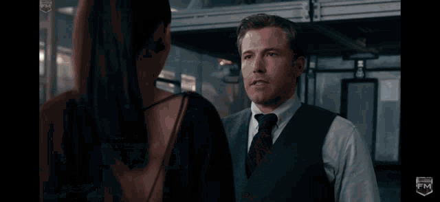 a man and a woman are looking into each other 's eyes in a dark room .
