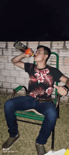 a man is drinking from a bottle while sitting on a chair