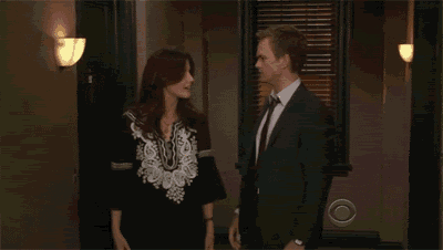 a man in a suit and tie is walking with a woman in a blouse