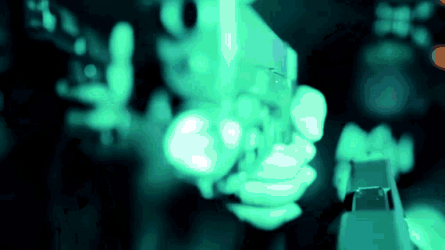 a person holding a gun with a green light behind it
