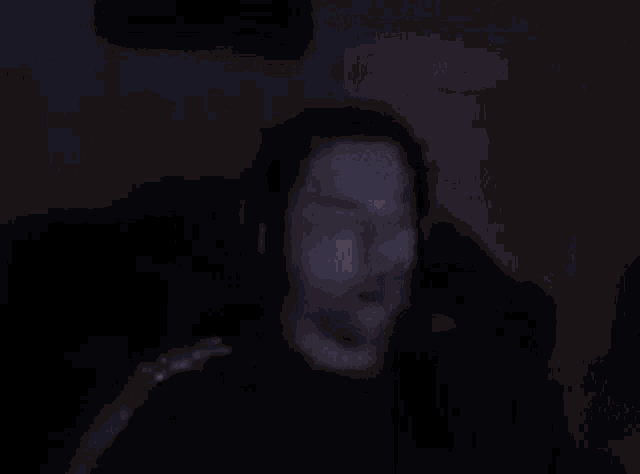 a blurry picture of a person drinking from a glass in the dark