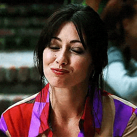 a woman with a nose ring is making a funny face while wearing a striped shirt .