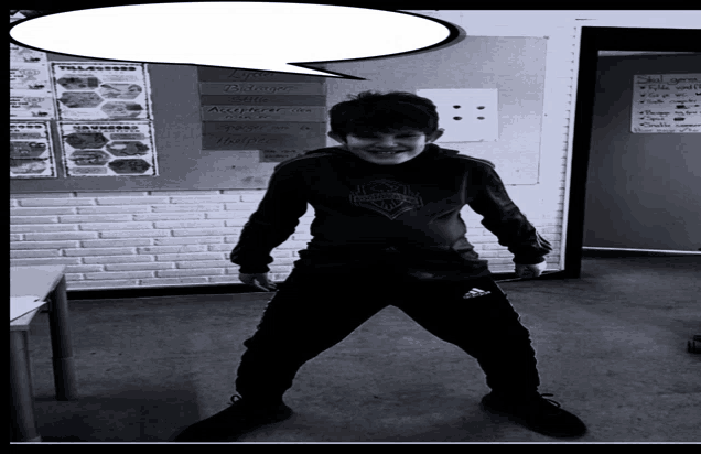 a black and white photo of a boy in front of a bulletin board with a speech bubble above him