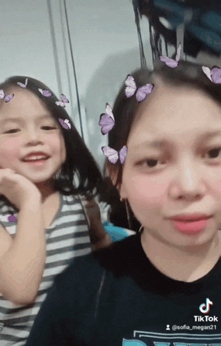 a woman and a little girl with butterflies on their hair
