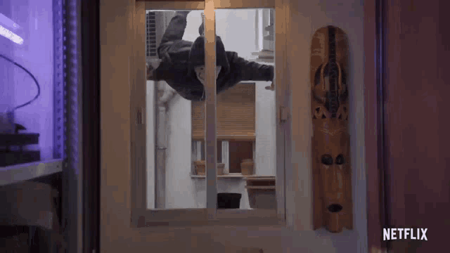 a netflix advertisement shows a man jumping through a window