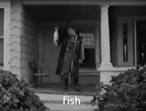 a black and white photo of a man holding a fish with the word fish below him