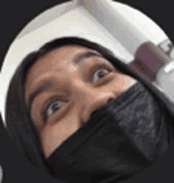 a close up of a person wearing a black mask on their face