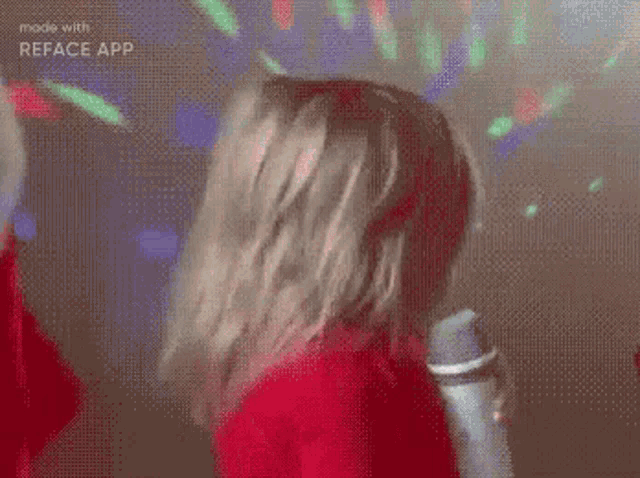 a little girl is holding a microphone and wearing a hat .